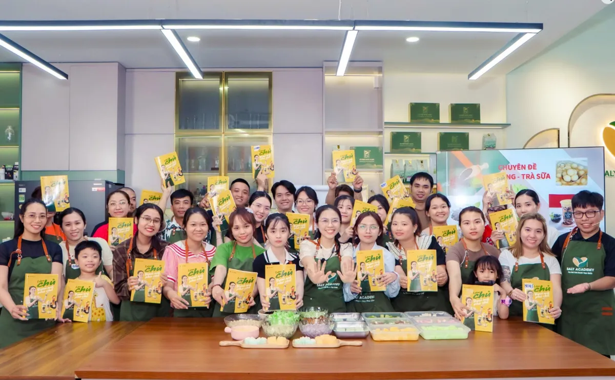 Học viên Saly Academy cầm sách Làm chủ từ đam mê pha chế tại lớp chuyên đề trà sữa