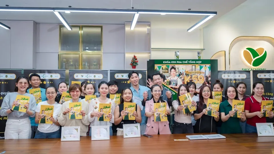 Học viên khóa K59 pha chế tổng hợp cầm sách Làm chủ từ đam mê pha chế tại Saly Academy