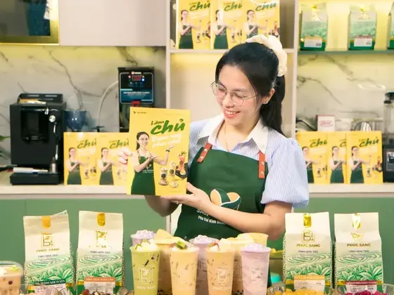 Giảng viên Ly Phạm cầm sách tại quầy pha chế